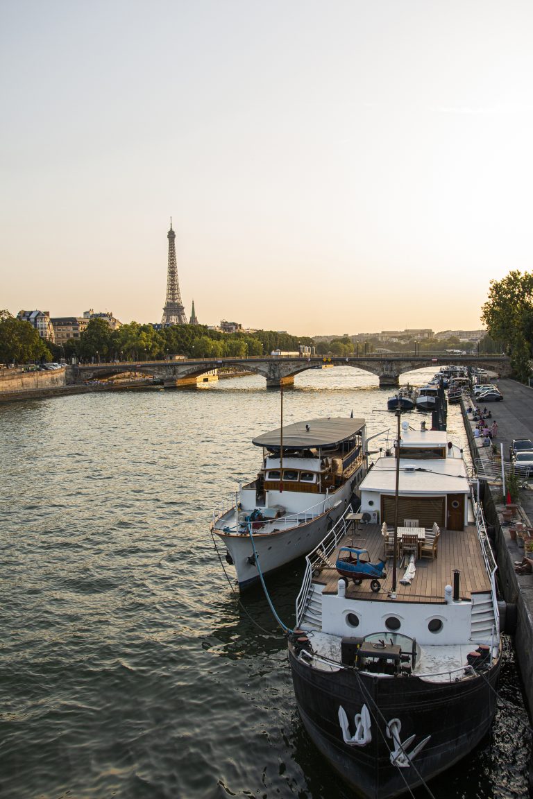 A high angle shot of a docked yacht on the river with Eiffel tower background in Paris
